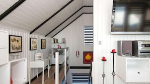 A modern kitchen with white cabinetry, a built-in microwave, and a large flat-screen TV. - Fantastic Holiday Home with Bay View near Knebel (Knebel)