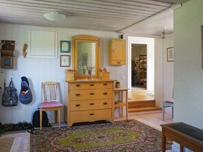 A room with a wooden dresser, a chair, a rug, and a mirror. - 5 Person Holiday Home in Kristinehamn (Kristinehamn)