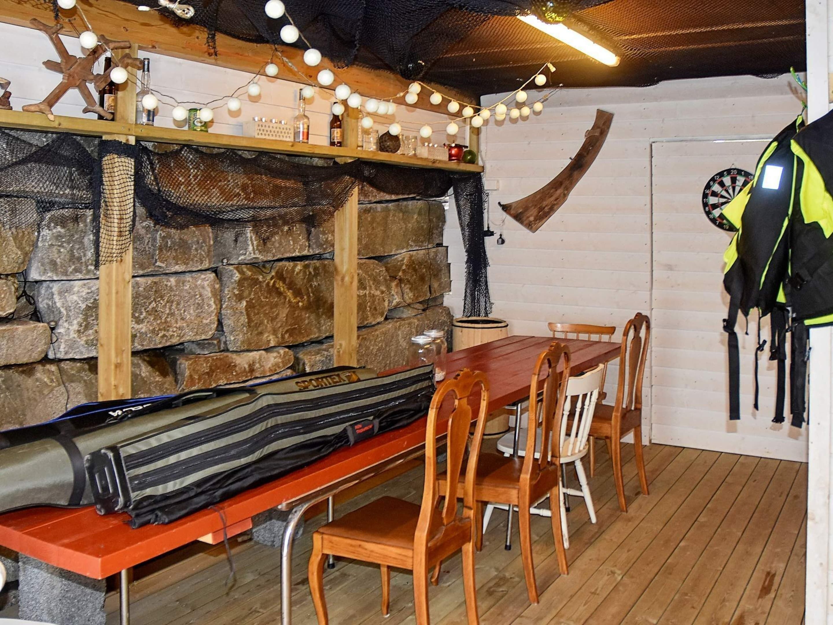 A rustic dining area with a stone wall, wooden table, and chairs.
