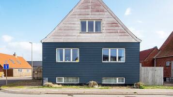 A two-story house with a gabled roof and a dark blue exterior.