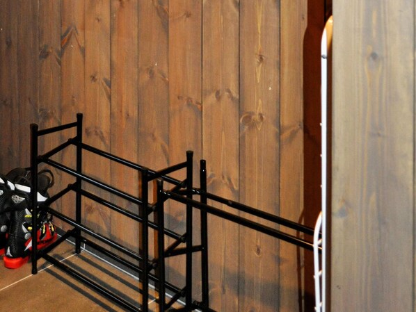 A room with a wooden wall and a black metal rack with shoes. - Holiday Home in FÃ¥vang (Ringebu)