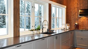 Una cucina moderna con un'ampia finestra, rivestimenti in legno e un lavello in acciaio inossidabile.