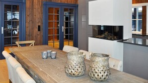Zona pranzo con tavolo in legno, sedie e oggetti decorativi.