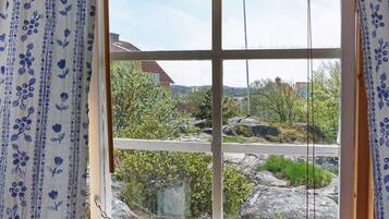 Una ventana con vistas a una zona residencial, con casas y vegetación.