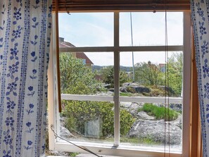 Una finestra amb vista a una zona residencial, amb cases i vegetació.