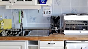Eine Küche mit Spüle, Kaffeemaschine und Kühlschrank.