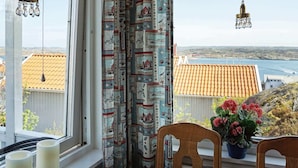 Ein Zimmer mit Meerblick, ein Tisch mit Kerzen und eine Zimmerpflanze.