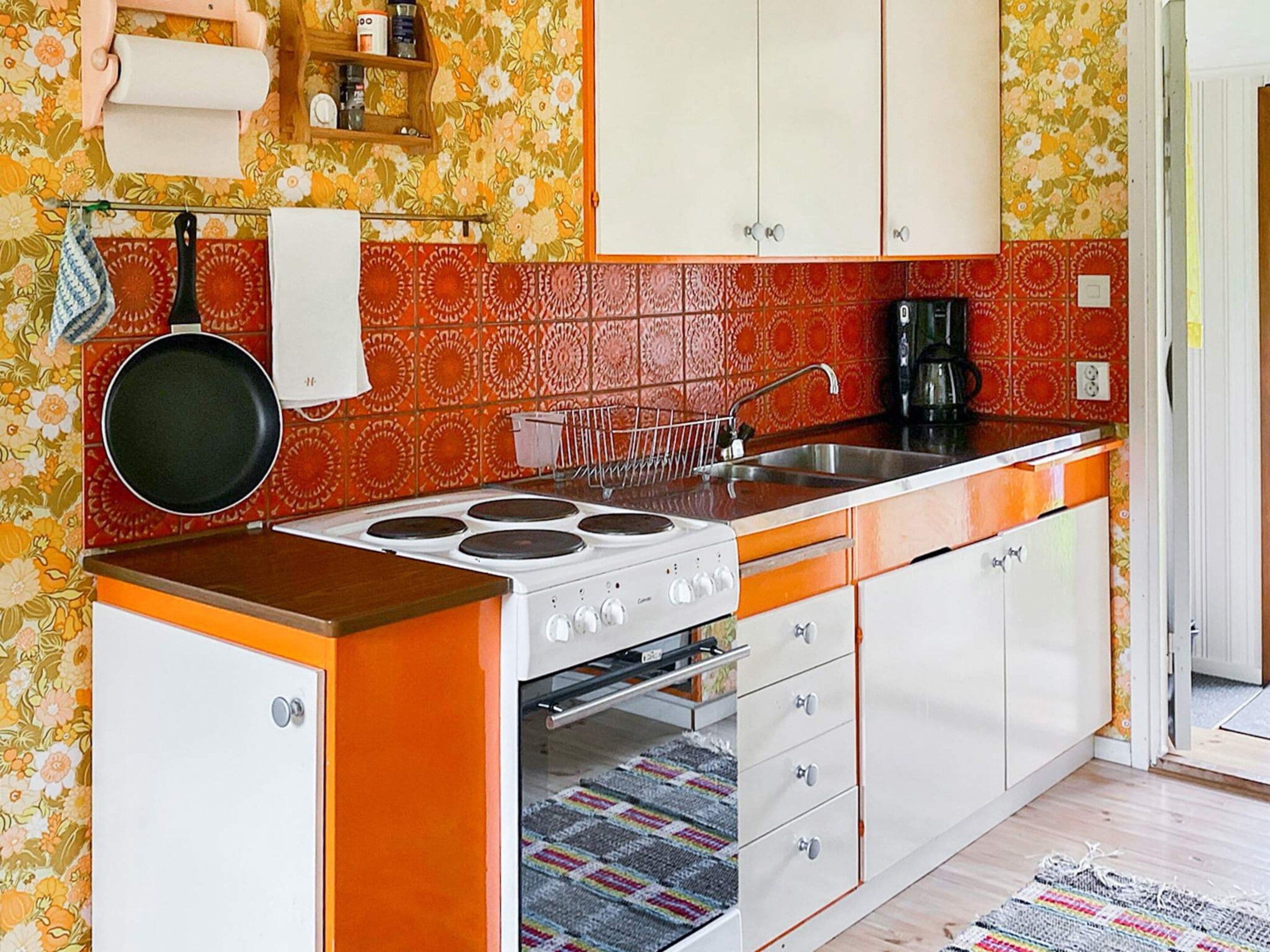 A kitchen with a stove, sink, and cabinets.