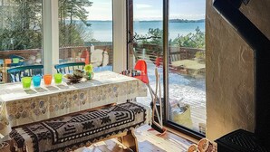 A cozy dining area with a table set for four, a bench, and a view of the beach. - 5 Person Holiday Home in OS (Bjørnafjorden)