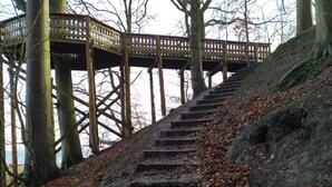 A wooden staircase leading up to a wooden viewing platform with a lattice railing. - 4 Person Holiday Home in Juelsminde (Horsens)