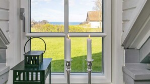A room with a large window divided into four panes, a green bench, and two candles. - Idyllic Holiday Home in Funen near Sea (Middelfart)