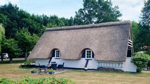 A thatched-roof house with two windows and a small porch area. - Idyllic Holiday Home in Funen near Sea (Middelfart)