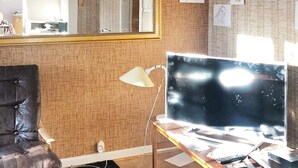 A room with a large mirror, a desk with a computer, a chair, and a wall with some papers and drawings. - 6 Person Holiday Home in Skorovatn (Namsskogan)