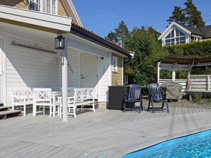 A wooden deck with outdoor seating and a pool. - 10 Person Holiday Home in Kongshavn (Arendal)