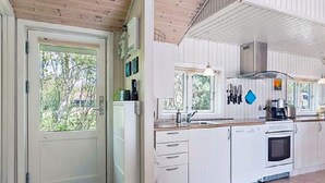 A modern kitchen with white cabinetry, a built-in oven, and a window overlooking greenery. - 4 Person Holiday Home in Hurup Thy-by Traum (Hurup Thy)