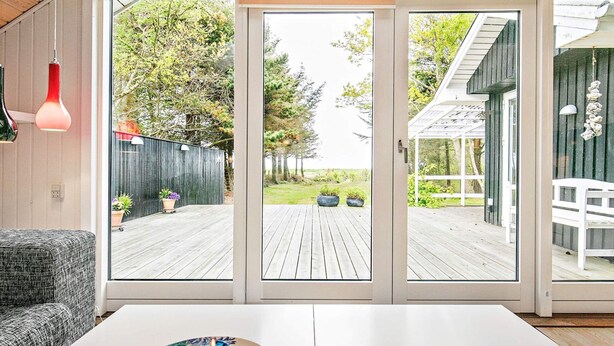 A modern interior with a sliding glass door leading to a wooden deck. - 4 Person Holiday Home in Hurup Thy-by Traum (Hurup Thy)