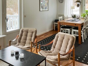 A room with two beige armchairs, a wooden dining table, and a black coffee table. - 4 Person Holiday Home in Nordkoster (Stromstad)
