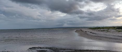 A beach with a wide sandy area and a body of water.