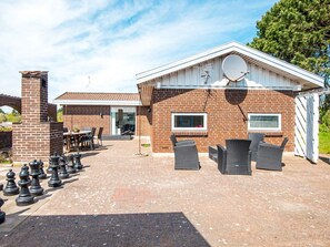 A residential property with a brick exterior, a satellite dish, and a patio area with outdoor furniture.