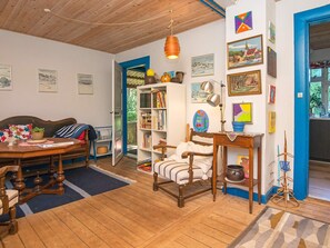 A cozy room with a wooden ceiling, a bed, a bookshelf, and a dining area with a table and chairs. - 6 Person Holiday Home in Braedstrup (Braedstrup)