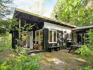 A cabin with a porch, a bench, and a table. - 4 Person Holiday Home in Bryrup (Bryrup)