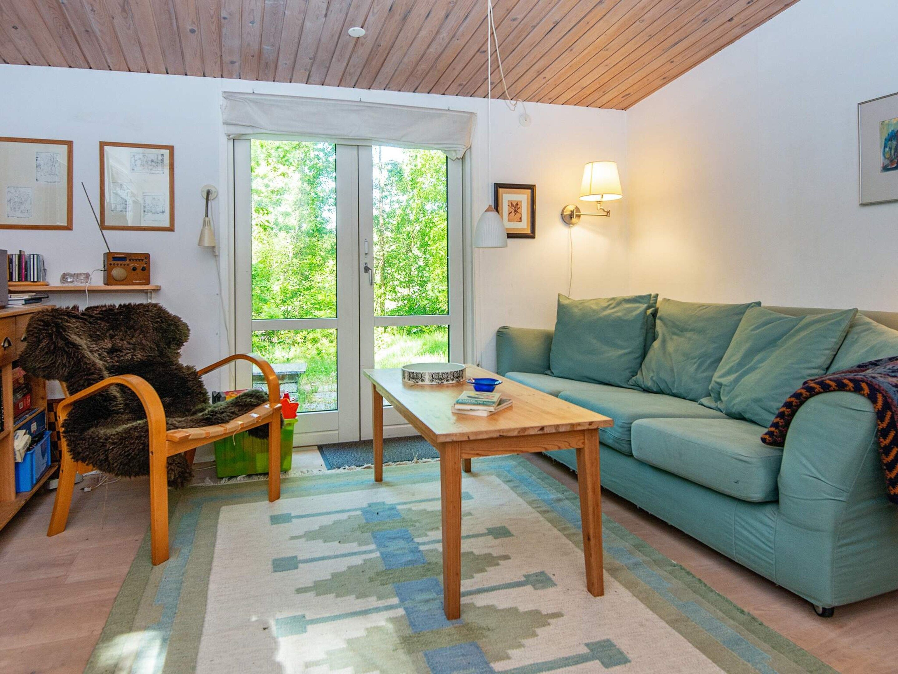 A cozy living room with a sofa, a wooden coffee table, and a rug.