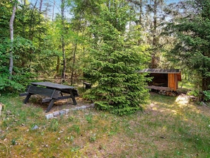 A forested area with a wooden bench and a small wooden structure. - 4 Person Holiday Home in Bryrup (Bryrup)