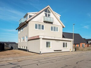 A two-story residential building with a balcony on the upper floor, a visible address sign, and a street in front. - 6 Person Holiday Home in Thyboron (Thyborøn)