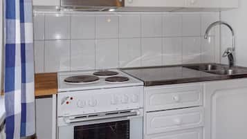 A kitchen with a stove, oven, and a stainless steel sink.
