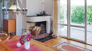 Una habitación acogedora con chimenea, muebles de madera y vistas al exterior.