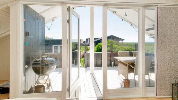 A room with a sliding glass door leading to an outdoor patio with a table and chairs.