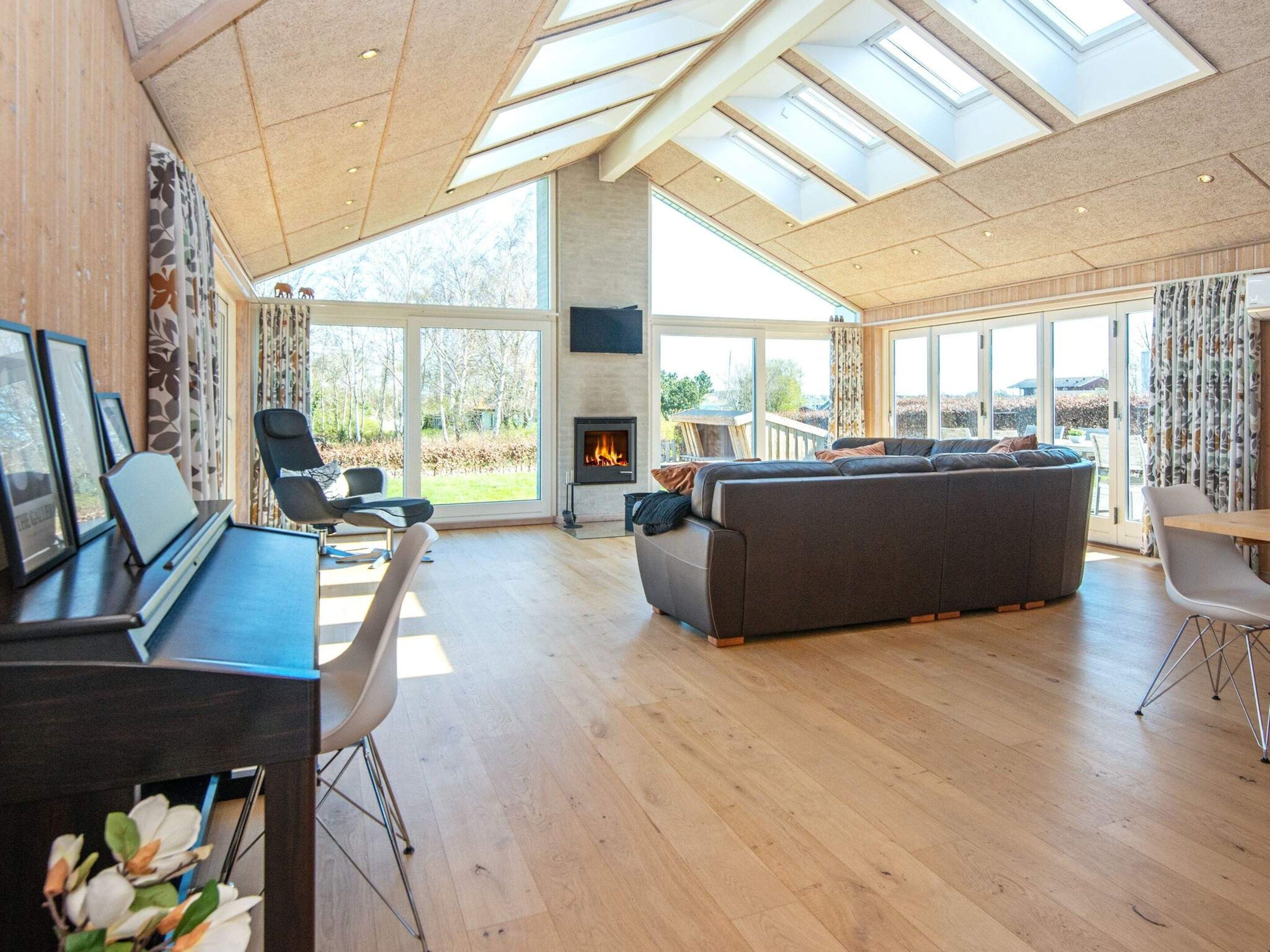 A spacious living area with a fireplace, a sofa, and a dining table.