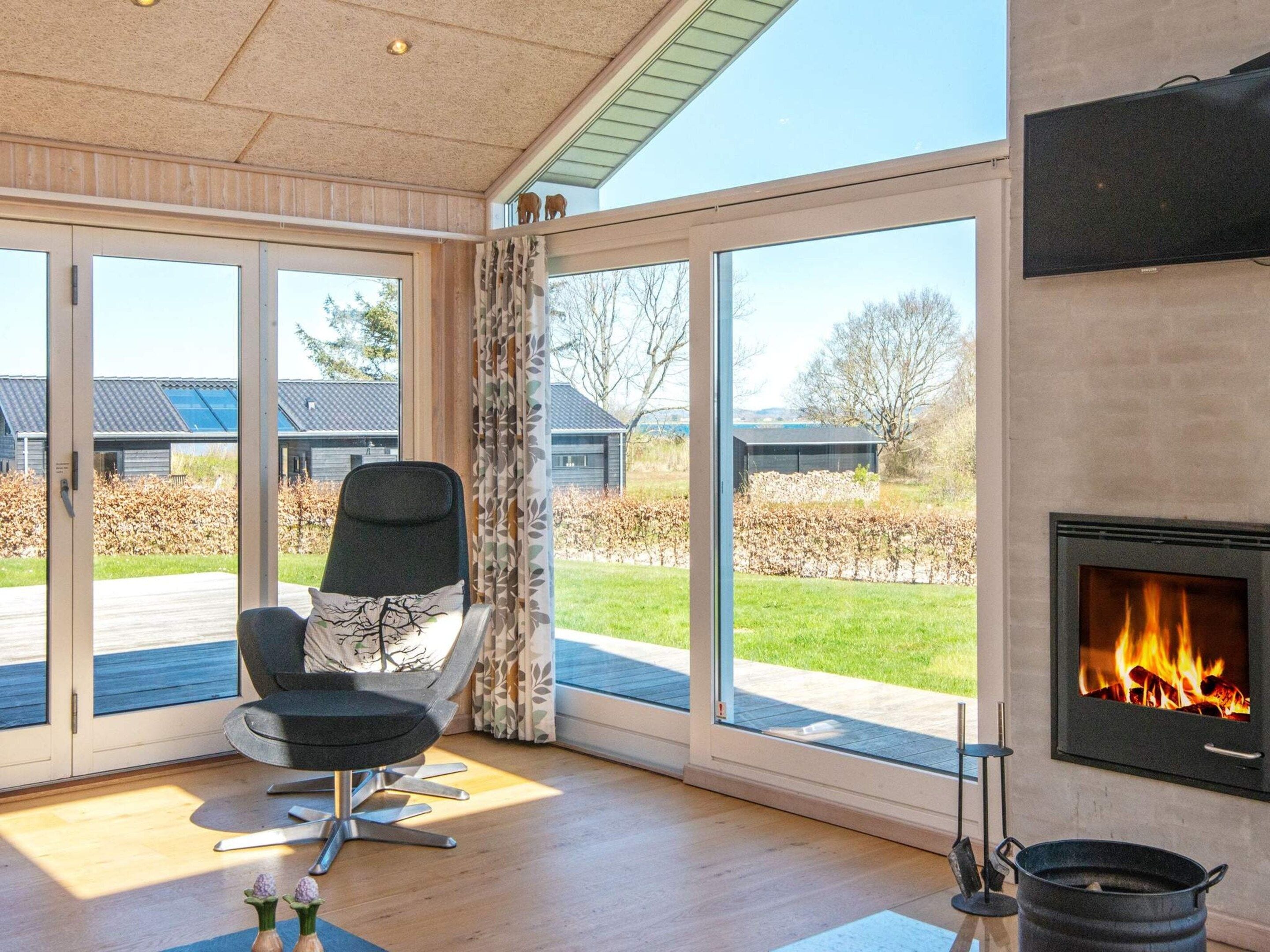 Un intérieur moderne avec une cheminée, de grandes fenêtres et un coin salon.
