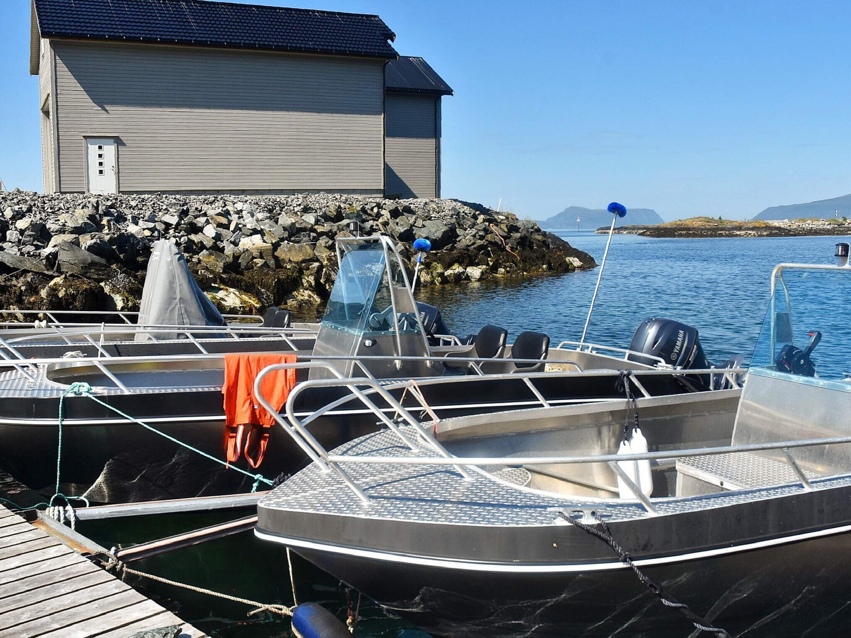 Ein Boot liegt an einem Steg, im Hintergrund ein Gebäude.