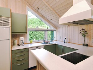 A kitchen with a window, a sink, and a built-in stove. - 4 Star Holiday Home in Gorlev (Gørlev)