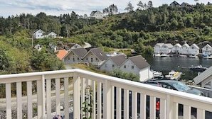 A coastal residential area with houses, a dock, and boats. - Holiday Home in Auklandshamn (Sveio)