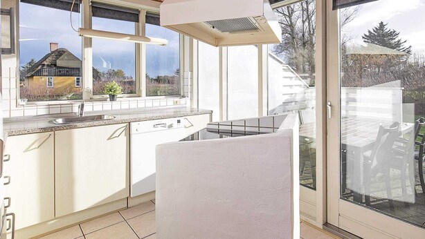 Una cucina moderna con un'ampia finestra, forno a incasso e una porta scorrevole in vetro che dà su un patio.