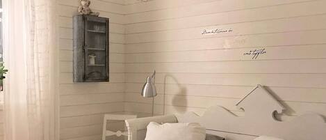 A bedroom with two beds, a nightstand, a lamp, and a shelf with a teddy bear.