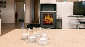 Un salon avec une cheminée, un téléviseur et une table décorée de bougies.