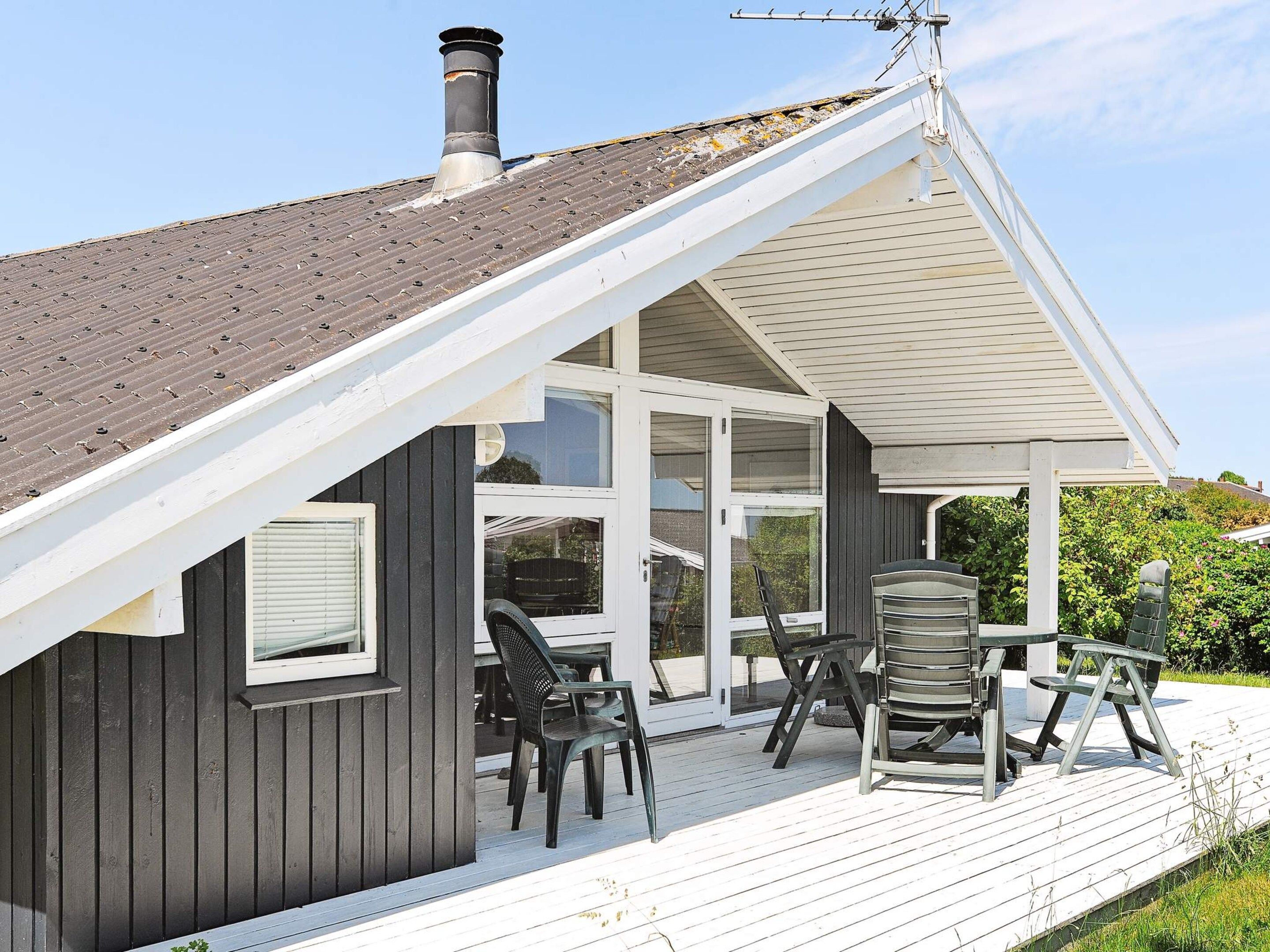 A house with a covered porch, a chimney, and a satellite dish.