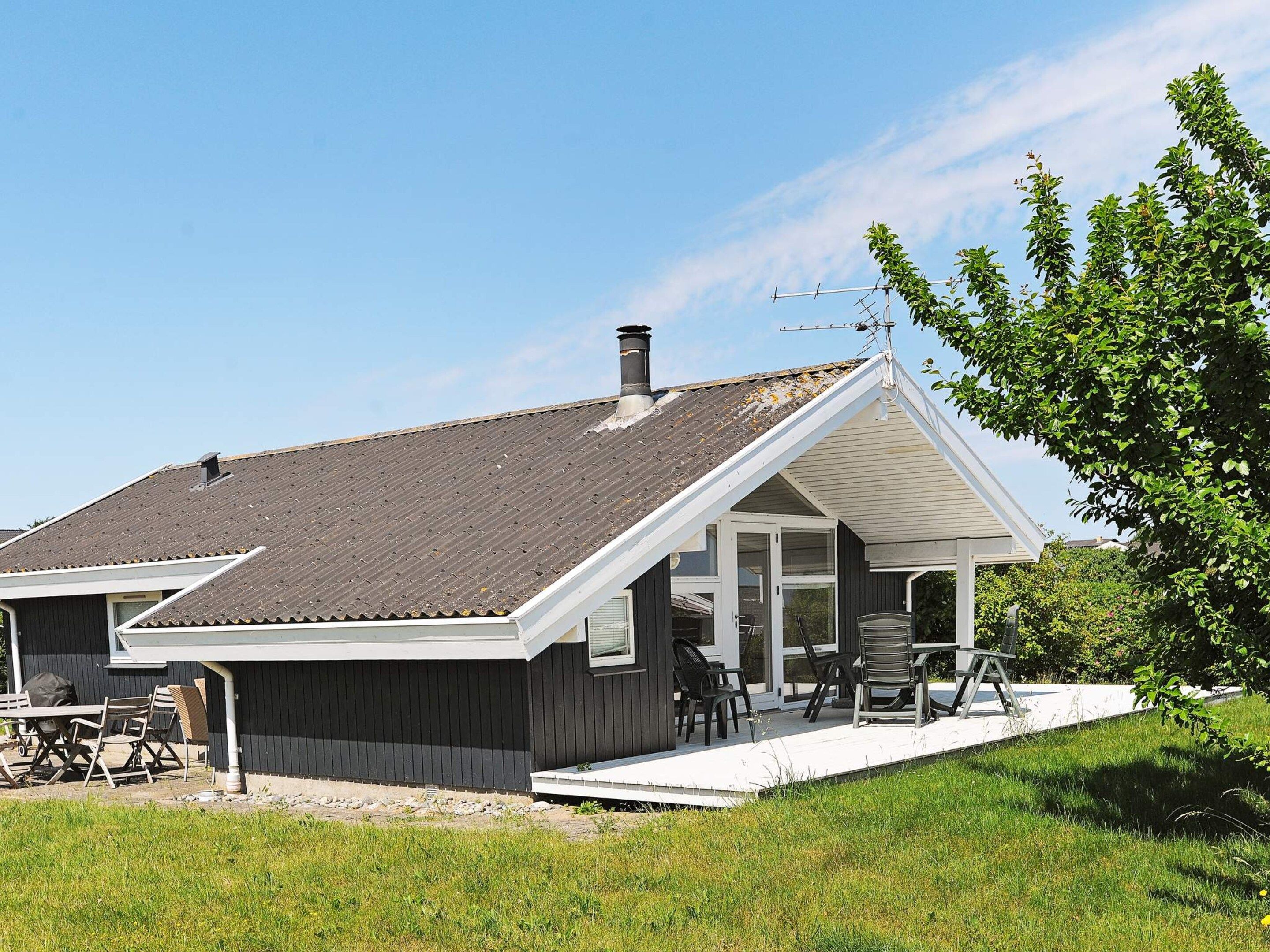 A modern house with a sloped roof, a covered porch, and a chimney.