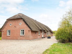 A brick building with a thatched roof and a gravel driveway. - 5 Star Holiday Home in Ulfborg (Ulfborg)