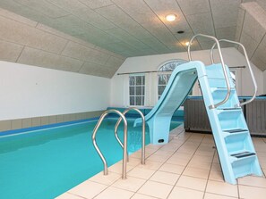 An indoor swimming pool with a slide, a hot tub, and a window. - 5 Star Holiday Home in Ulfborg (Ulfborg)