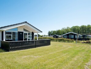 A modern vacation home with a large deck, a fenced yard, and a clear view of the surrounding area. - 5 Star Holiday Home in Juelsminde (Horsens)