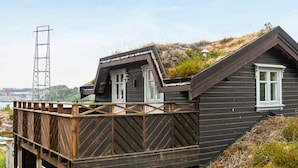 A wooden house with a sloped roof and a wooden deck. - 4 Star Holiday Home in Frei (Kristiansund)