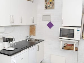 A kitchen with white cabinets, a coffee maker, a microwave, and a sink. - 3 Person Holiday Home in Grasten (Grasten)