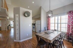 Enjoy family meals in this dining area with a wooden table and chairs, perfect for casual gatherings.