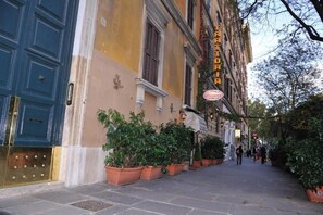 A building with a sign reading "TRATTORIA" and a blue door. - Double B Carlo Alberto (Rome)
