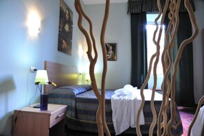 A hotel room with a bed, a nightstand with a lamp, and a window with curtains. - Double B Carlo Alberto (Rome)