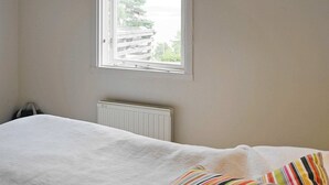 Ein Schlafzimmer mit Bett, Fenster und Heizkörper.